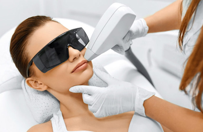 A woman is receiving laser hair removal on the upper lip